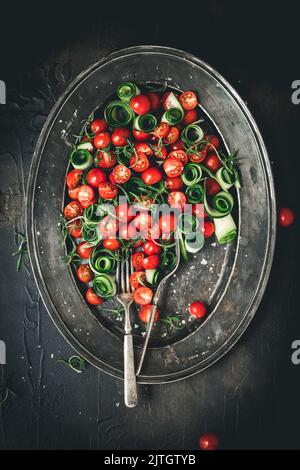 Tomaten- und Gurkensalat auf einem Metallteller Stockfoto
