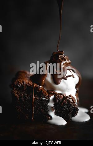 Schokoladenbrownie mit Eis und geschmolzener Schokolade Stockfoto
