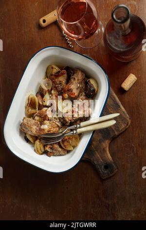 Im Ofen gebackene Schweineribs mit Zwiebeln. Ländliches Stillleben, Cottagecore-Stil Stockfoto