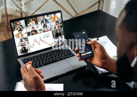 Börse. Erfolgreicher afroamerikanischer männlicher Krypto-Trader, der eine Online-Videokonferenz mit multirassischen Kollegen abhielt, den Aktienmarkt, mögliche Risiken, Aufstieg und Fall diskutierte und analysierte Stockfoto