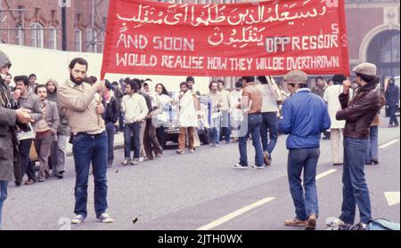 30. April 1980, London, Großbritannien: Iranische Anhänger mit einem großen Protestbanner marschieren in London während der sechstägigen Belagerungsaktion der iranischen Botschaft. Vom 30. April bis zum 5. Mai 1980 übernahm eine Gruppe von sechs bewaffneten iranischen Dissidenten, die sich gegen Ayatollah Khomeini, den religiösen Führer, der 1979 an die Macht kam, ausssetzten, die iranische Botschaft am Prince's Gate in South Kensington, London. Die iranische Gruppe nahm 21 Geiseln, von denen zwei getötet wurden. In der Nähe der Belagerungsszene machten Anhänger von Khomeini ihre Ansichten mit einem Protest bekannt. Die dramatische sechstägige Belagerungszeit endete, als die britischen SAS-Elitetruppen St Stockfoto