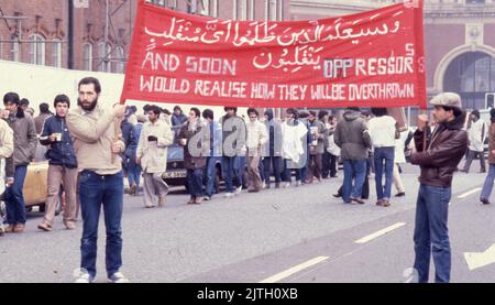 30. April 1980, London, Großbritannien: Iranische Anhänger mit einem großen Protestbanner marschieren in London während der sechstägigen Belagerungsaktion der iranischen Botschaft. Vom 30. April bis zum 5. Mai 1980 übernahm eine Gruppe von sechs bewaffneten iranischen Dissidenten, die sich gegen Ayatollah Khomeini, den religiösen Führer, der 1979 an die Macht kam, ausssetzten, die iranische Botschaft am Prince's Gate in South Kensington, London. Die iranische Gruppe nahm 21 Geiseln, von denen zwei getötet wurden. In der Nähe der Belagerungsszene machten Anhänger von Khomeini ihre Ansichten mit einem Protest bekannt. Die dramatische sechstägige Belagerungszeit endete, als die britischen SAS-Elitetruppen St Stockfoto