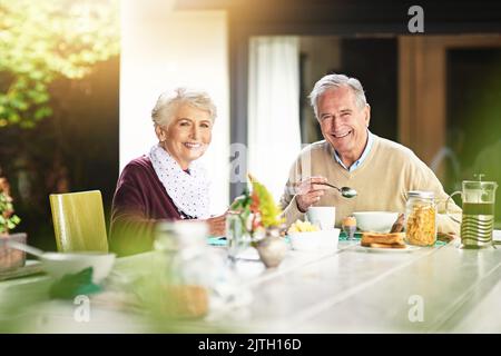 Es ist der beste Start in den Tag. Porträt eines glücklichen älteren Ehepaares, das zu Hause gemeinsam frühstücken kann. Stockfoto