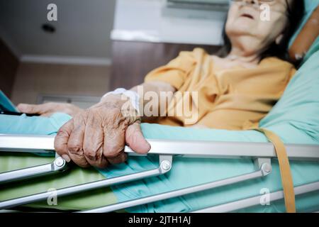 Kranke südostasiatische weibliche ältere Patientin mit Atemwegserkrankungen Bettruhe im Krankenhaus Stockfoto