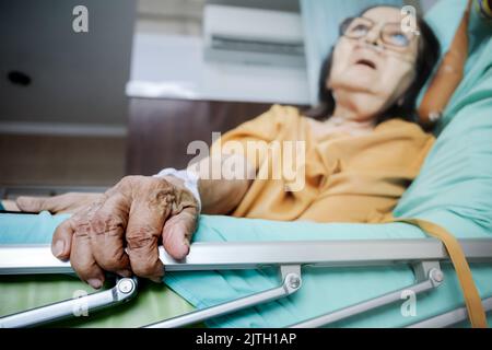 Kranke südostasiatische weibliche ältere Patientin mit Atemwegserkrankungen Bettruhe im Krankenhaus Stockfoto