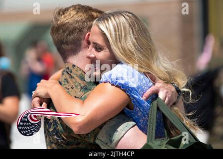 San Diego, Kalifornien, USA. 12. August 2022. Ein US-Marine mit Marine Fighter Attack Squadron 314, Marine Aircraft Group 11, 3. Marine Aircraft Wing umarmt seinen Ehepartner bei der Rückkehr von der USS Abraham Lincoln auf der Marine Corps Air Station Miramar, August. 11, 2022. Der historische Einsatz markierte die erste Staffel des US Marine Corps F-35C, die an Bord eines US Navy-Flugzeugträgers eingesetzt wurde, und sicherte das Engagement von 3. MAW, Festflügeljägerflugzeuge für den Einsatz als Teil der US Navy-Trägerflugflügel bereitzustellen, die regelmäßig in der Indo-Pazifik-Region eingesetzt werden. (Credi Stockfoto