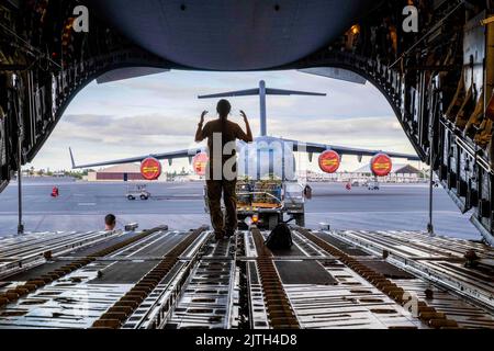 Hawaii, USA. 23. August 2022. Der Senior Airman Jolan Besse, Ladermeister der 535. Airlift Squadron, leitet einen K-Lader an, um Ladung auf einen C-17 Globemaster III zu laden, um eine Fallübung auf der Joint Base Pearl Harbor-Hickam, Hawaii, August, zu unterstützen. 24, 2022. AirDrop-Übungen bieten Airmen reale Trainingsmöglichkeiten, um die Mission des 15. Wing zur schnellen globalen Mobilität voranzutreiben. Quelle: U.S. Air Force/ZUMA Press Wire Service/ZUMAPRESS.com/Alamy Live News Stockfoto