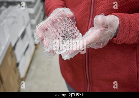 Mädchen gegen Viren Handschuhe kaufen Glas für starke alkoholische Getränke im Geschäft Stockfoto