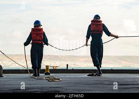 Indischer Ozean. 9. August 2022. Bootsmann's Mate Seaman Giselle Olivera, links, aus Rancho Cordova, Kalifornien, und Seaman Henry Klososky, rechts, aus Chicago, heavten eine Linie an Bord des Expeditions-Seestützpunktes USS Hershel 'Woody' Williams (ESB 4) der Lewis B. Puller-Klasse, August. 9, 2022. Hershel 'Woody' Williams wird im Einsatzgebiet der US Naval Forces Africa, das von der US Sixth Fleet eingesetzt wird, rotationell eingesetzt, um die Interessen der USA, der Alliierten und der Partner zu verteidigen. Quelle: U.S. Air Force/ZUMA Press Wire Service/ZUMAPRESS.com/Alamy Live News Stockfoto