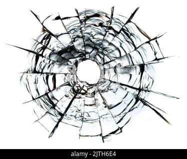 Risse im Glas, ein Loch aus Kugeln im Glas auf weißem Hintergrund. Glasstruktur des Fensters. Stockfoto