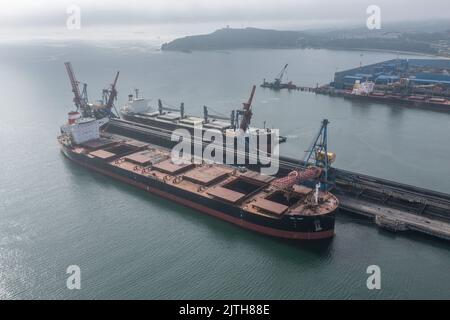 Nachodka, Russland - 31. Juli 2022: Die Seeschiffe werden an einer Anlegestelle beladen. Stockfoto