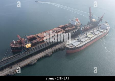 Nachodka, Russland - 31. Juli 2022: Die Seeschiffe werden an einer Anlegestelle beladen. Stockfoto