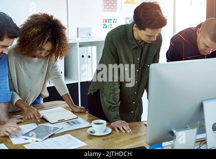 Wir engagieren uns dafür, einander beim Lernen zu helfen. Geschäftsleute, die in Teams in einem modernen Büro arbeiten. Stockfoto