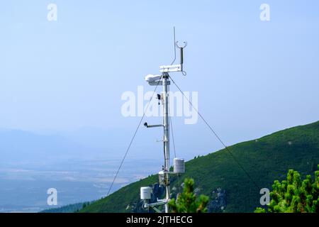 Anemometer, eine kleine meteorologische Station in der Tatra auf einem Hintergrund von blauem Himmel und Nadelbäumen Stockfoto