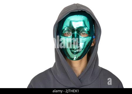 Ein Mädchen in einer Vollmaske aus Kunststoff und in einer Kapuze auf einem isolierten Hintergrund, Anonymität, versteckt ihr Gesicht Stockfoto