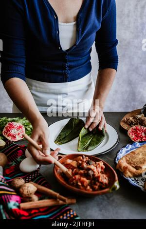 mexikanische Frau Kochen Chiles en nogada Rezept mit Poblano Chili und Zutaten, traditionelles Gericht in Mexiko Stockfoto