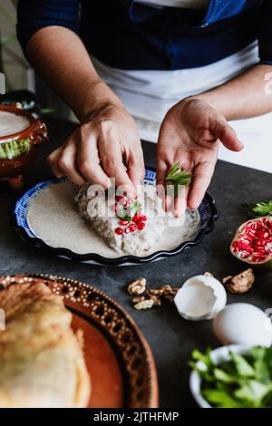 mexikanische Frau Kochen Chiles en nogada Rezept mit Poblano Chili und Zutaten, traditionelles Gericht in Mexiko Stockfoto