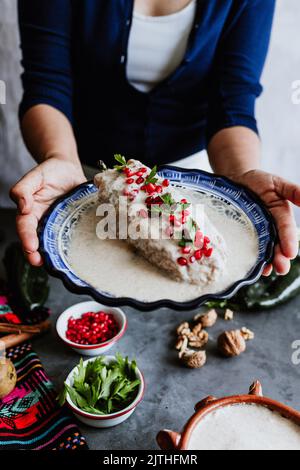 mexikanische Frau Kochen Chiles en nogada Rezept mit Poblano Chili und Zutaten, traditionelles Gericht in Mexiko Stockfoto