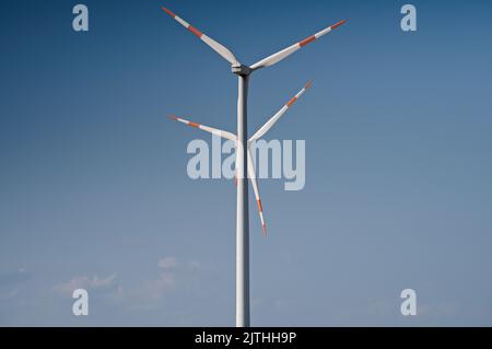 Zwei Windturbinen gegen blauen Himmel Stockfoto