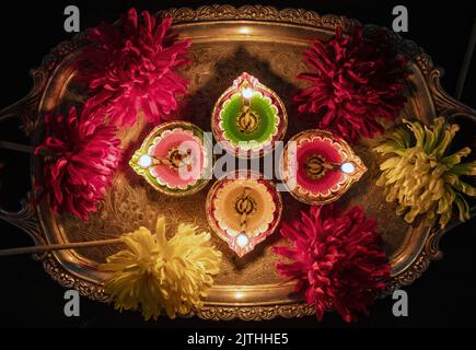 Diwali, Deepavali Hindu Festival der Lichter Feier. Diya Öllampe beleuchtet auf traditionellem Puja thali, Draufsicht. Stockfoto