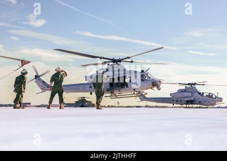 US-Marineinfanteristen mit HMLA (Light Attack Helicopter Squadron) 773 beobachten einen UH-1Y Venom Hubschrauber, der ebenfalls dem HMLA 773 zugewiesen wurde, der von der Fluglinie auf der McGuire Air Force Base, New Jersey, am 16. August 2022 abhebt. HMLA 773 startete drei UH-1Y Venom und zwei AH-1Z Viper Hubschrauber von der McGuire Air Force Base und startete sie an Bord des Anlegeschiffs USS Mesa Verde (LPD 19) der San Antonio Klasse, um eine bevorstehende multinationale Übung zu unterstützen. (USA Marine Corps Foto von CPL. Colton K. Garrett) Stockfoto