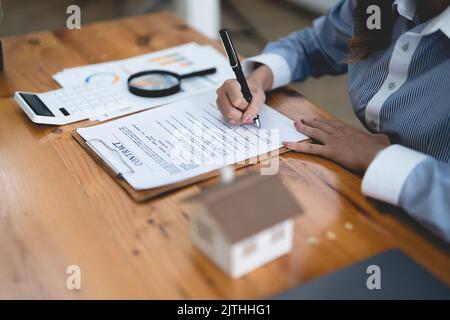 Frau Unterzeichnung Mietvertrag bei der Sitzung mit makler oder Vermieter, Immobilienkauf, Hypothek und Darlehen Eigentumskonzept Stockfoto