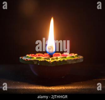 Deepavali Diwali. Hinduistisches Lichterfest. Diya-Kerze aus Ton. Öllampe leuchtet auf dunklem Hintergrund, Kopierraum. Stockfoto