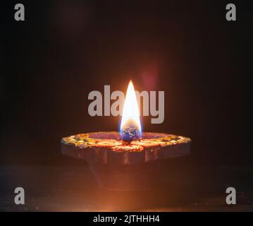 Diwali. Deepavali hinduistisches Lichterfest. Diya-Kerze aus Ton. Öllampe leuchtet auf dunklem Hintergrund, Kopierraum. Stockfoto