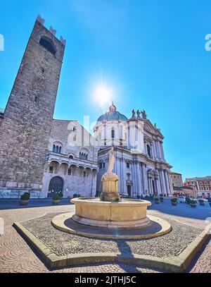 Die sonnige Piazza Paolo VI mit dem antiken Minerva-Brunnen, der mittelalterliche Palazzo Broletto und der prachtvolle Neue Dom (Duomo Nuovo), Brescia, Lombardei, Italien Stockfoto