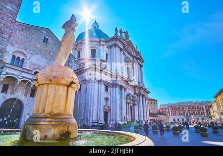 BRESCIA, ITALIEN - 10. APRIL 2022: Die Piazza del Duomo (Paolo VI) mit dem alten Minerva-Brunnen, dem Broletto-Palast und dem Duomo Nuovo (Neue Kathedrale), auf AP Stockfoto