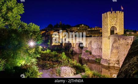 Mittelalterliche Brücke, die den Fluss in der alten Stadt Besalu bei Nacht, Gerona, Spanien überquert. Stockfoto