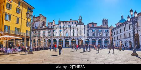 BRESCIA, ITALIEN - 10. APRIL 2022: Panoramablick auf das historische Gebäude mit Arkaden und Torre dell'Orologio (Uhrenturm) mit astronomischer Uhr und Br Stockfoto