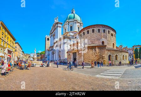 BRESCIA, ITALIEN - 10. APRIL 2022: Panorama von Paolo VI oder Cathedral Square von Brescia mit Restaurants und Cafés gegen die farbigen historischen Häuser, B Stockfoto