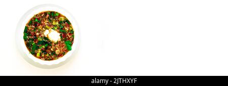 Traditionelles Sommergericht - kalter Borscht mit Kartoffeln, Ei, Kräutern, Rettich, Gurke, Rote Bete, Saure Creme. Ein Gericht aus ukrainischer, polnischer und russischer Küche. Weißer isolierter Hintergrund. Stockfoto