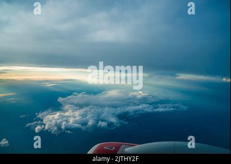 Panorama-Luftaufnahme. Schöner Sonnenuntergang Himmel über Wolken mit dramatischem Licht. Blick auf die Kabine vom Flugzeug aus. Passagierflugzeug. Geschäftsreise. Kommerziell Stockfoto