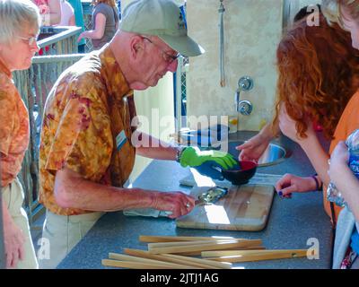 Ein Mann benutzt ein Austernmesser, um Austern zu öffnen. Stockfoto