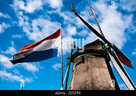 Traditionelle Windmühle mit holländischer Flagge bei De Zaanse Schans Stockfoto