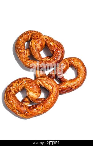 Oktoberfest-Konzept - Brezeln isoliert auf weißem Hintergrund. Traditionelles Symbol, trendiges hartes Licht, dunkler Schatten, flaches Lay Stockfoto