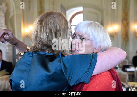 Meseberg, Deutschland. 31. August 2022. Claudia Roth (Bündnis 90/die Grünen - r), Staatsministerin und Beauftragte der Bundesregierung für Kultur und Medien, wird vor der Kabinettssitzung in einer geschlossenen Sitzung von einer unbekannten Frau begrüßt. Sie hatten zuvor erfahren, dass der grüne Politiker Hans-Christian Ströbele gestorben war. Quelle: Tobias Schwarz/POOL-POOL/dpa/Alamy Live News Stockfoto