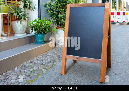 Leeres Schild oder Menuboard am Eingang des Restaurants oder Blumenladens. Café-Menü auf der Straße. Tafel Schild Mockup, Schild, f Stockfoto