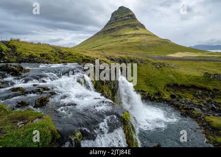 Kirkjufell (Kirchberg) mit dem Wasserfall Kirkjufellsfoss im Vordergrund, Snaefellsnes Peninsula, Island Stockfoto