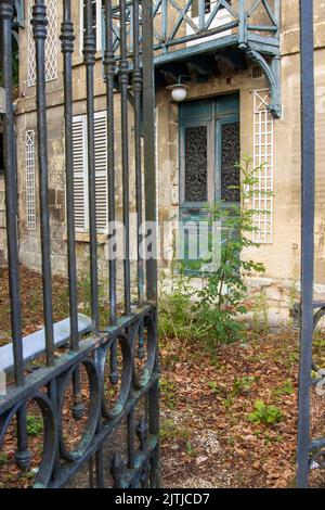 Offenes Tor, das zur Eingangstür eines verlassenen Hauses führt. Hochwertige Fotos Stockfoto
