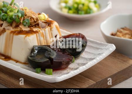 Köstliche gekühlte Tofu- und Century Egg Food mit Sojasauce und Bonito-Flocken in Taiwan. Stockfoto