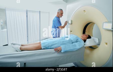 CT-Scan-MTRA mit Blick auf eine Patientin im CT-Scanner während der Einstellungen am Computertomographen Stockfoto