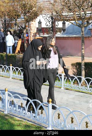 ISTANBUL, TÜRKEI-OKTOBER 30:nicht identifiziertes religiöses Mädchen mit schwarzem Burka, das mit ihrer Freundin in Sultanahmet spazierend ist.Oktober 30,2021 in Istanbul, Türkei Stockfoto