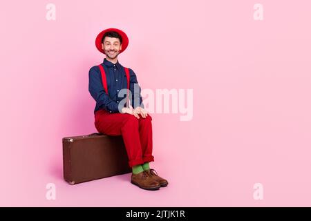 Foto in voller Größe von jungen gut aussehenden attraktiven schönen Studenten Kerl Sitztasche positive fröhlich leeren Raum ad isoliert auf rosa Hintergrund Stockfoto