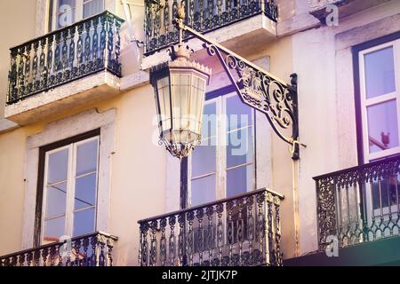 Klassische Laterne und schmiedeeiserne Balkone in Lissabon. Typische Architektur in Portugals Hauptstadt. Stockfoto