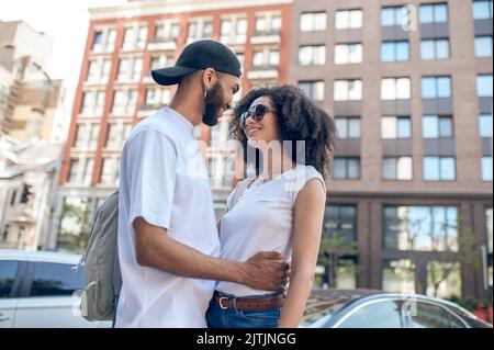 Ein Mann umarmt eine junge Frau und schaut verliebt Stockfoto