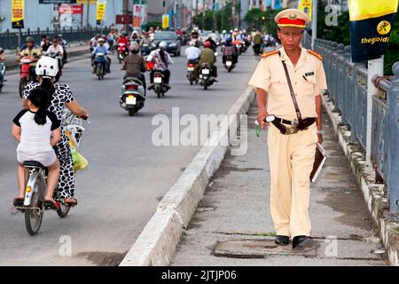 Vietnamesischer Verkehrspolizist, der auf der Straße läuft, Hai Phong, Vietnam Stockfoto