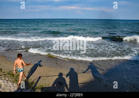 Odessa, Ukraine. 10. August 2022. Im August 2022 gehen Menschen in Odessa, Ukraine, an einem Strand mit Warnschildern schwimmen, die darauf hinweisen, dass es sich um meine Sünde im Wasser handelt. Odessa war ein beliebter Touristenort zum Schwimmen und einen Tag am Strand vor der russischen Invasion. Jetzt schwimmen die Menschen auf eigenes Risiko, da Minen angelegt wurden, um sich gegen Vorstöße des russischen Militärs aus dem Schwarzen Meer zu verteidigen. (Foto: Teun Voeten/Sipa USA) Quelle: SIPA USA/Alamy Live News Stockfoto